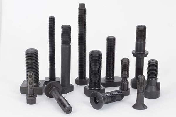 Parafusos industriais de diferentes tamanhos em fundo branco.